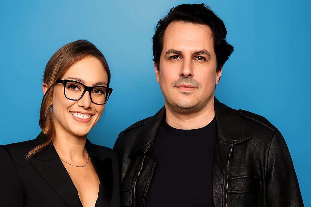 Kat Timpf's husband poses beside her in a formal portrait, both dressed in black attire against a light blue background, reflecting their public presence and media appeal.